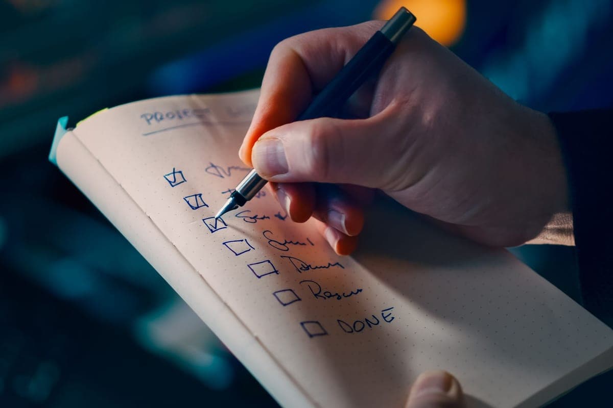 A hand ticking off a handwritten checklist